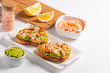 Appetizer toasted bruschetta with mashed avocado and shrimps on background. Healthy food concept with prawns.