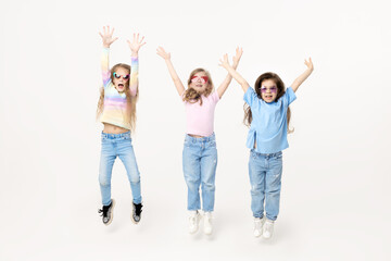 Group portrait of kids girls friends on white studio background. Happy children, cute girls hugging and having fun in carnival glasses. funny faces