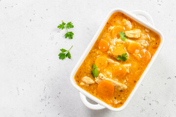 Turkey carrot goulash in ceramic dish. Top view, copy space, flat lay.