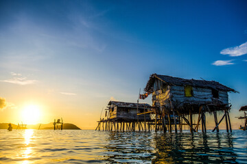 A picturesque Bajau Laut stilt houses by the breathtaking backdrop of a radiant sunrise or sunset.