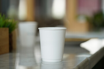 Fototapeta na wymiar Cup on a cafe table White cafe paper cup. 3D rendering, mockup. 