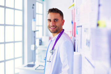 Young and confident male doctor portrait standing in medical office. - 624005989