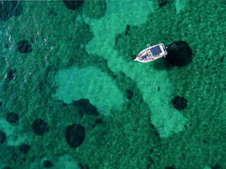 aerial view from the drone of a dinghy boat immersed in the Caribbean and crystal clear emerald sea