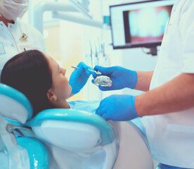 Senior male dentist in dental office talking with female patient and preparing for treatment - 624009783