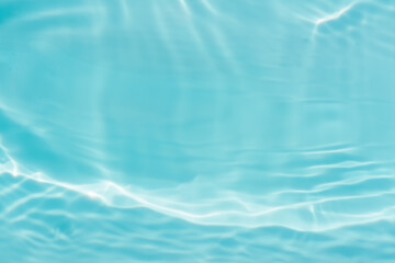 Blue water with ripples on the surface. Defocus blurred transparent blue colored clear calm water surface texture with splashes and bubbles. Water waves with shining pattern texture background.