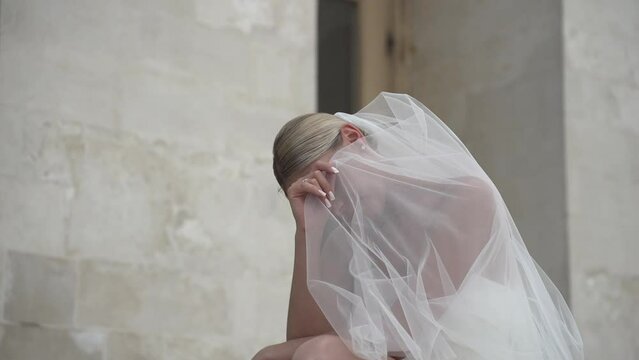 Bride covers her face with a veil