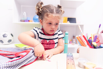 Ready for Back-to-School: Little Girl Preparing Her School Bag for Activities