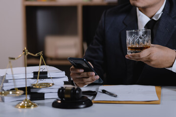 Law holding a glass of whiskey at desk, justice and law, attorney, court judge, concept.
