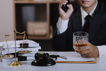 Law holding a glass of whiskey at desk, justice and law, attorney, court judge, concept.
