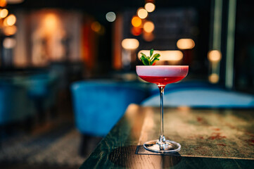 alcohol cocktail in a glass stands on a table in a bar or restaurant