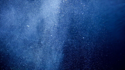 Air bubbles floating and rising up to the sea surface. Sun light shining through ocean. Abstract...