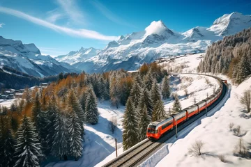 Poster de jardin  Drone view. The train goes among the Alpine mountains. AI generated. The mountain peaks are covered with snow.  © serperm73