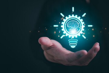 Creative thinking ideas and innovation concept with Businessman holding glowing drawing lightbulb with virtual brain and connection line.