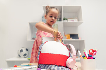 Getting Set for School: Little Student Packing Backpack with Essential School Supplies