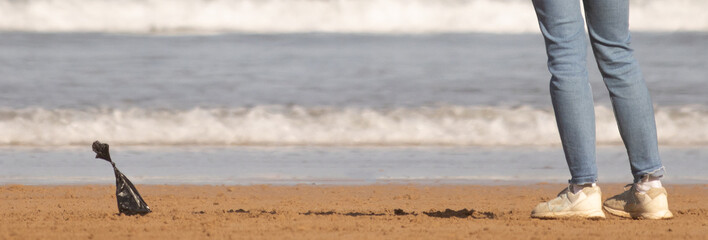 bag of dog poop on beach sand