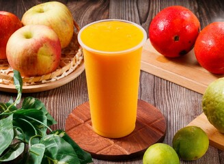 Fresh mango juice with raw fruits served in glass isolated on table top view of morning vitamins drink