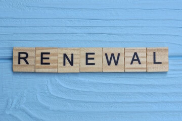 word renewal made from wooden gray letters lies on a blue background