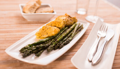 cooked dish. Chicken nuggets with green asparagus on plate