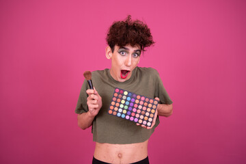 Make up. Funny drag queen posing in the studio on a pink background.