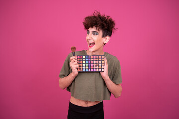 Make up. Funny drag queen posing in the studio on a pink background.