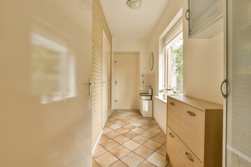 a bathroom with tile flooring and wood cabinets in the shower room, looking out to the garden through the window