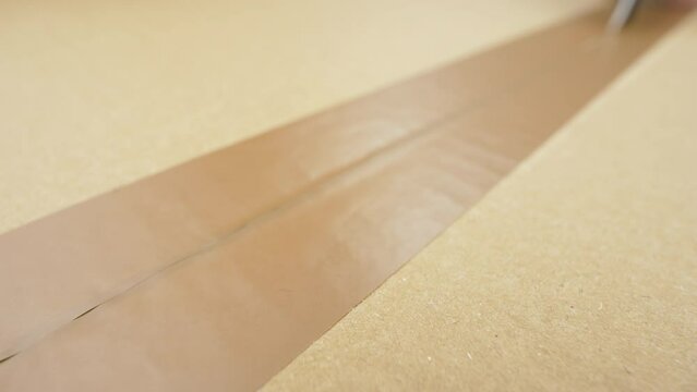 Carton parcel. Cutting cardboard with clerical knife. Opening a cardboard box