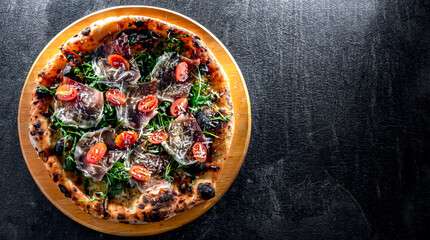 Pizza Italiana served with ham, cheese, tomatoes and rucola