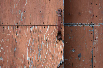 A rusty steel handle on a wooden panel