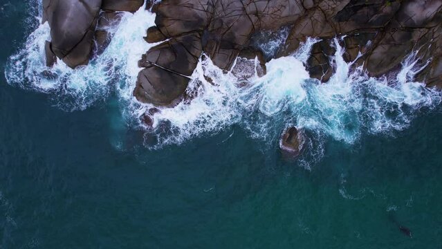 Aerial drone top down view bird eye view of sea blue waves break on rock and sand. Beautiful of sea water wave come to beach. Phuket Thailand tropical beach