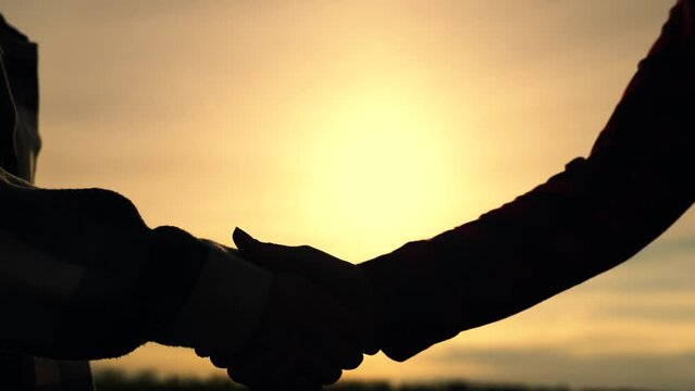 Hand silhouette, Handshake for conclusion of contract. Agriculture. Agribusiness. Teamwork of farmers. Handshake of farmers in field. Farmers enter into a contract. Agricultural business concept.
