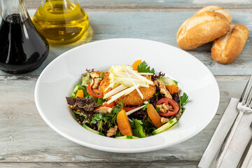 Deep fried goat cheese salad on a white porcelain plate