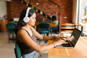 Latin freelancer woman doing remote work at the cafe