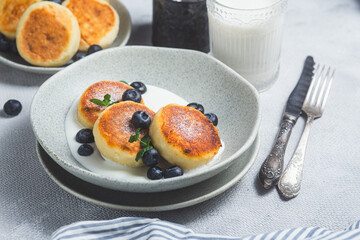 Cottage cheese pancakes with cream sauce and blueberries. syrniki 