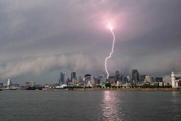 Naklejka na ściany i meble Lightning strike and shelf cloud from a supercell thunderstorm over Montreal city, Quebec, Canada