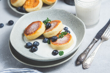 Cottage cheese pancakes with cream sauce and blueberries. syrniki 