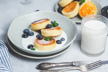 Cottage cheese pancakes with cream sauce and blueberries. syrniki 