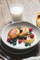 Cottage cheese pancakes with creamy sauce, raspberries and blueberries