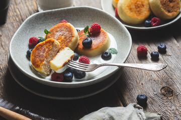 Cottage cheese pancakes with creamy sauce, raspberries and blueberries