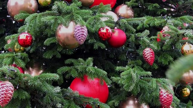 Video of a large Christmas tree decorated with balloons and a garland. New Year's fair on the street