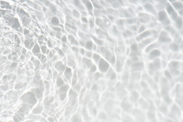 White water with ripples on the surface. Defocus blurred transparent white colored clear calm water surface texture with splashes and bubbles. Water waves with shining pattern texture background.