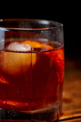 Alcoholic cocktail Negroni or non-alcoholic cocktail, drink with ice and orange peel as decoration on wooden table