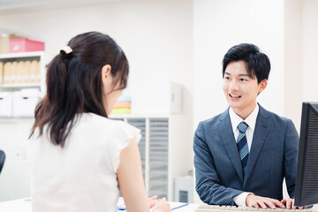 窓口で顧客の要望を聞く男性スタッフ