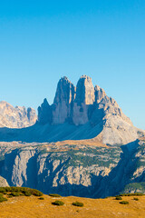 Beautiful magical Three Dolomite peaks at the national park Three Peaks, Tre Cime Di Lavaredo, Drei Zinnen in Autumn colors at blue sky and sunny day, South Tyrol, Italy