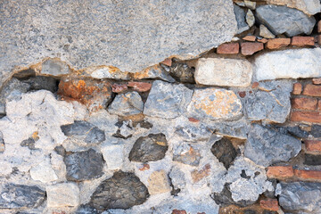 Empty aged weathered stonewall background texture. Old, worn, peeled structure backdrop. Copy space