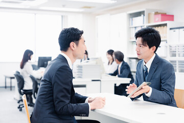 窓口でタブレットを用いて案内をする男性スタッフ