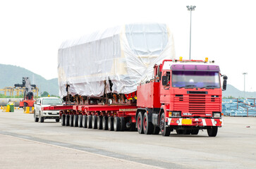 Transport of Oversize Heavy Machinery cargo truck Loading a new locomotive port area