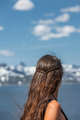 Frau mit Langen Haaren vor einem See im Gebirge