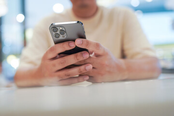Relaxed young asian man using smart phone  spending time checking news social media.