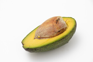 Side view of avocado sliced with seed on isolated white background.