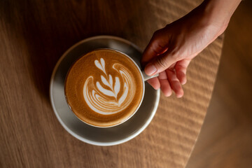 hot cappuccino with latte art on wood background